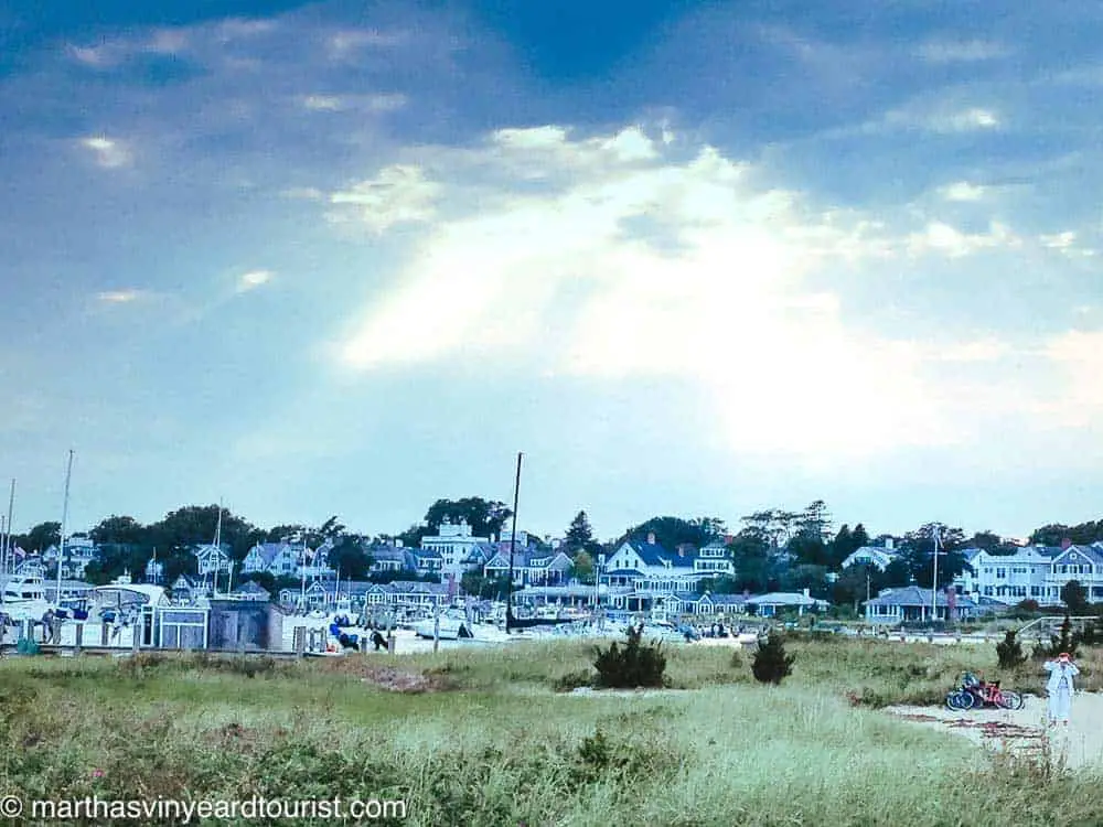 view of houses in Edgartown downtown from Lighthouse Beach with sun breaking through clouds