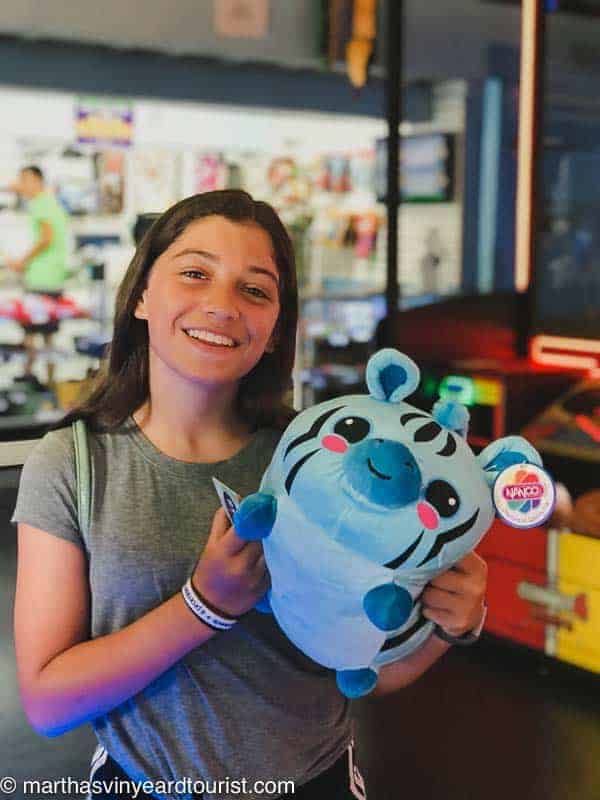 Girl with stuffed animal prize at an arcade