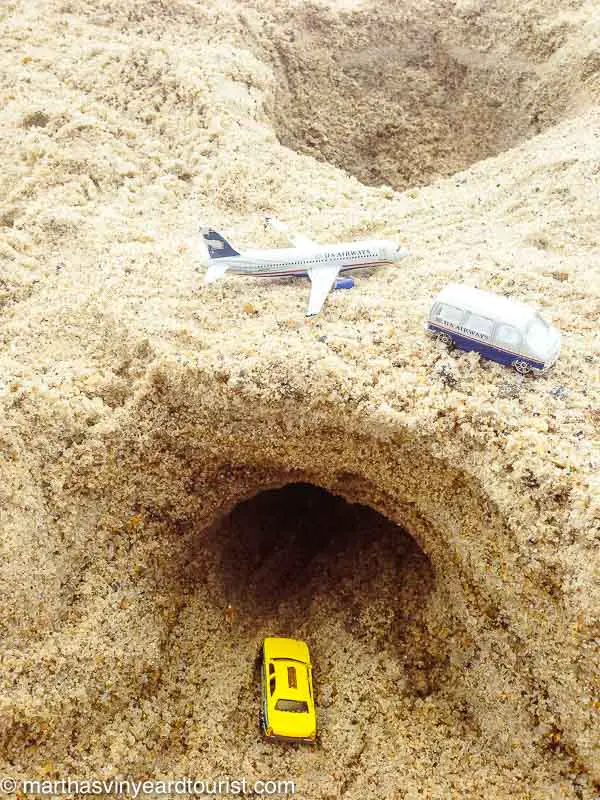 bridge and tunnel with toy cars and plane in sand