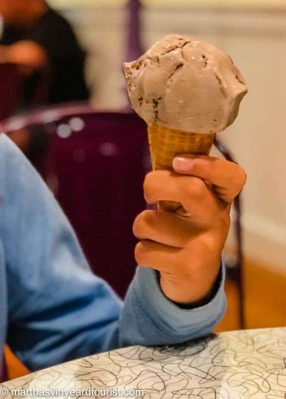 hand holding a hazelnut ice cream scoop on a cone