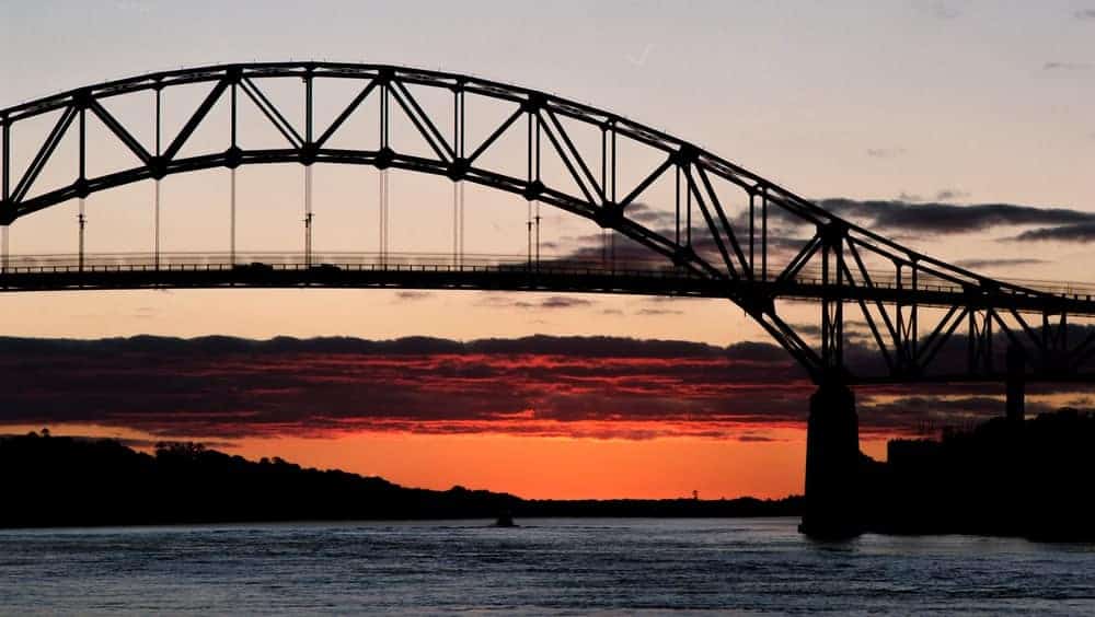 Sagamore Bourne Bridge to Cape Cod with an orange sunrise and purple clouds