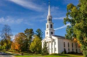 Traditional American Whithe Church with high Steeple under an Autumnal Blue Sk. Williamstown, MA.