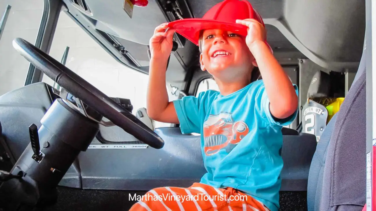 toddler in fire truck wearing a fire hat in Edgartown Martha's Vineyard