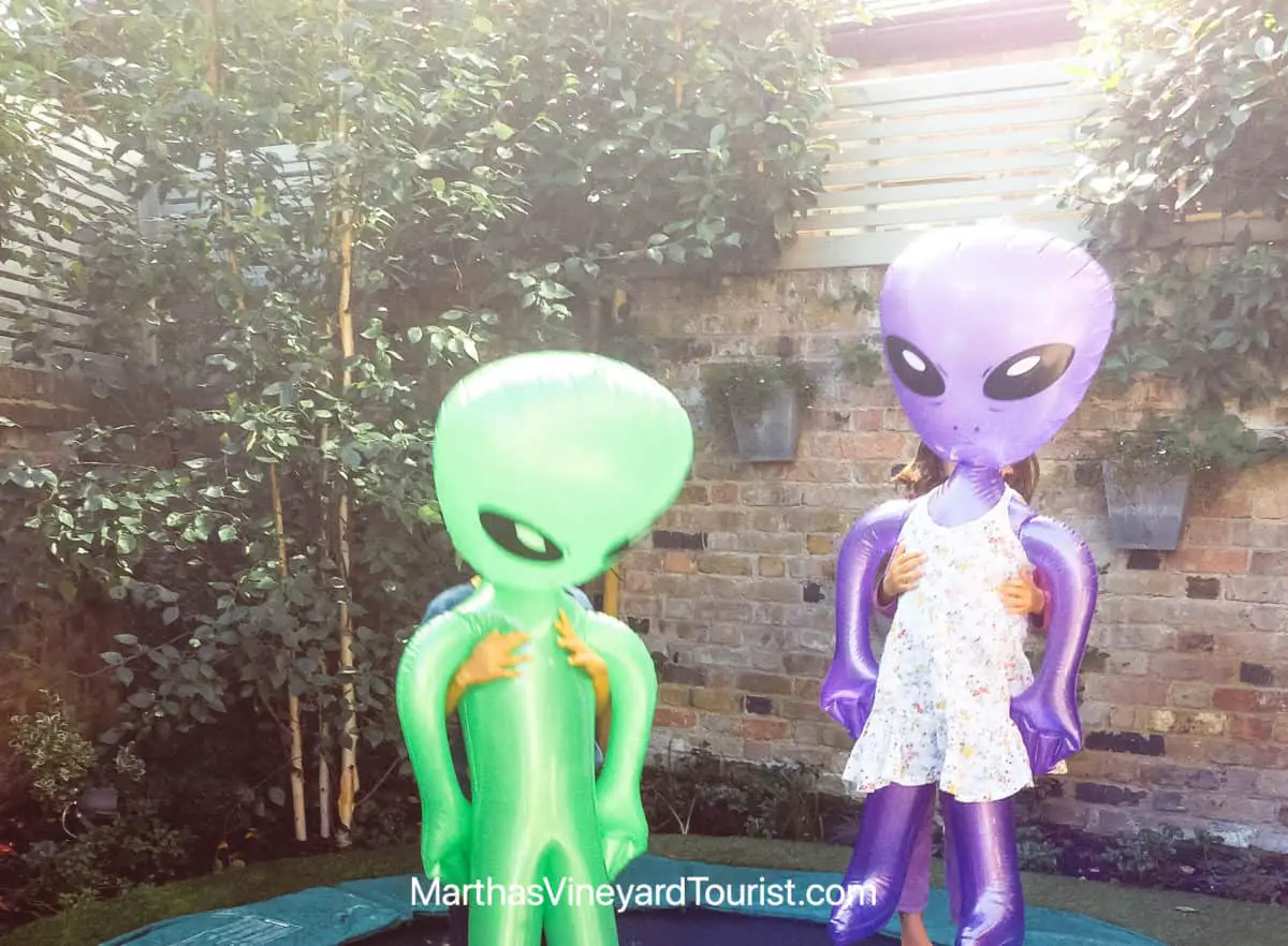 blow up alien dolls jumping on a trampoline